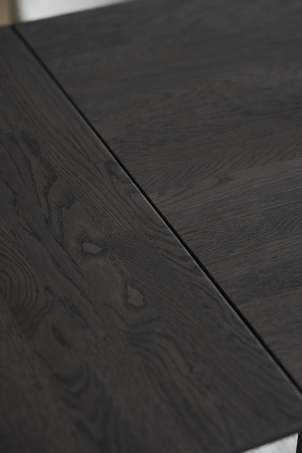 Närbild på mörkgrå trägolv med synlig trästruktur och fог mellan plankorna