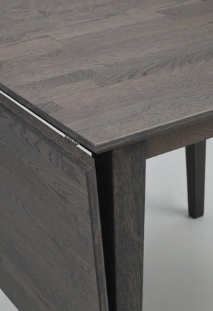 Närbild på mörkgrått skrivbord i trä med synlig trästruktur och ben, modern skandinavisk design