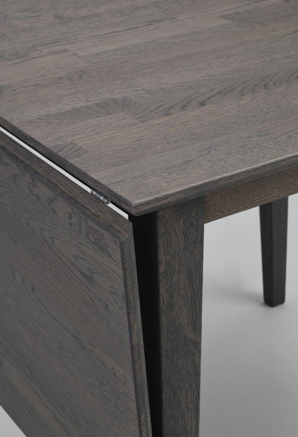 Närbild på mörkgrått skrivbord i trä med synlig trästruktur och ben, modern skandinavisk design