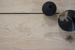 Svarta keramiska dekorationsvaser på ljust trägolv, modern inredning i skandinavisk stil