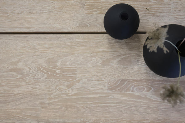 Svarta keramiska dekorationsvaser på ljust trägolv, modern inredning i skandinavisk stil