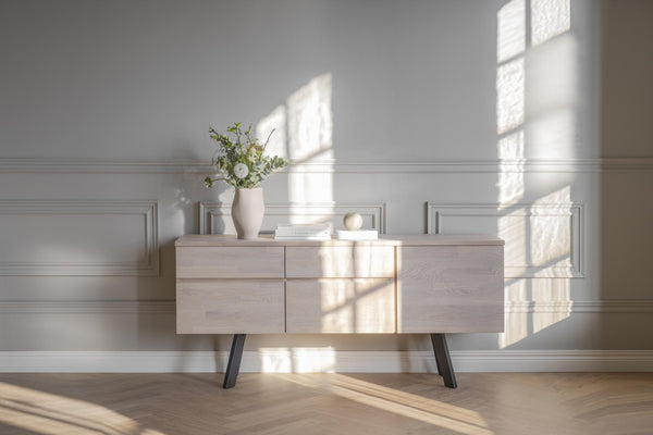 Ljust träskåp med svarta ben i modernt vardagsrum med naturligt ljus genom fönster