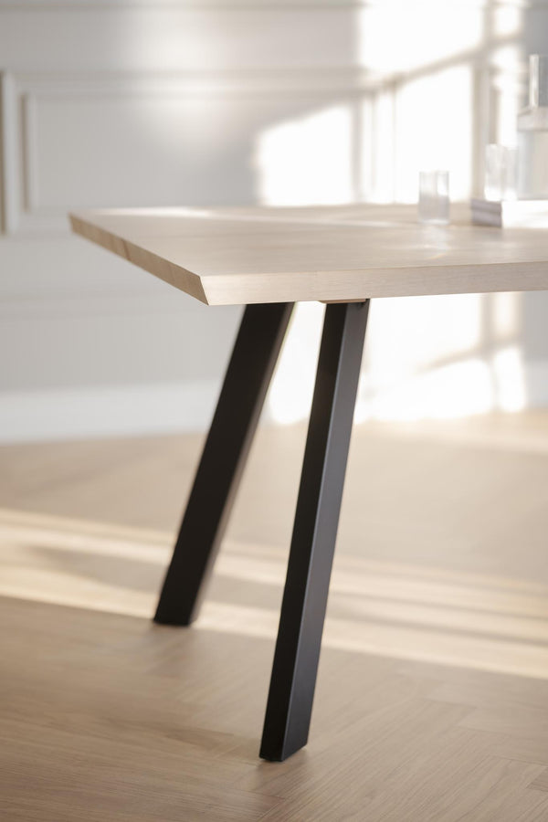 Matbord med ljus träskiva och svarta metallben i modern skandinavisk design