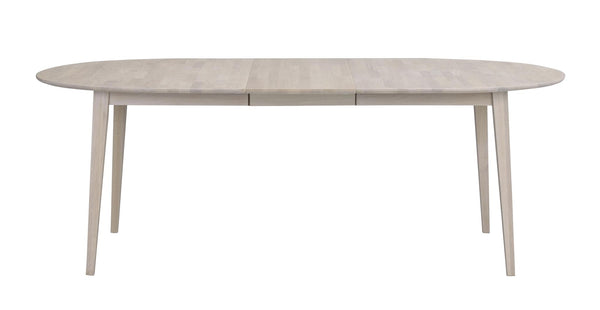 Ovalt matbord i ljust trä med utdragsfunktion och fyra smala ben i skandinavisk design