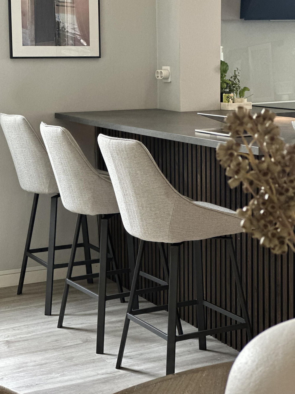 Barstol med beige stoppad sits och rygg, svarta metallben, modern design för kök eller bar