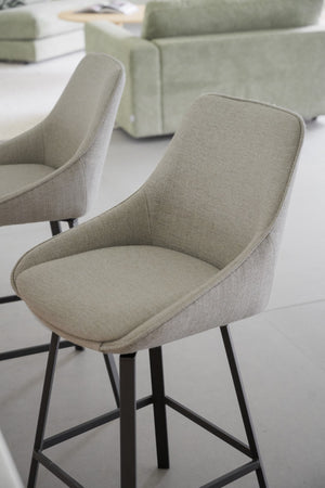 Ljusgrön barstol med hög rygg och metallben i modern miljö