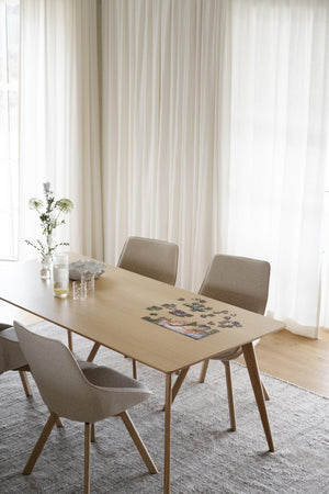 Matbord i ljust trä med tre beige stolar i skandinavisk design med träben