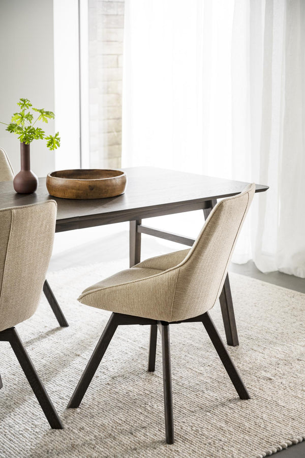 Beige matstol med svarta träben vid matbord i modern skandinavisk matsal