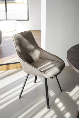 Grå matstol med svarta ben i modern skandinavisk design, placerad i ljust kök med stort fönster