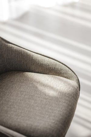 Närbild på lyxig sängkudde i sammet med metallisk gyllenbrun ton mot vit sängkläder