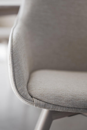 Närbild på grå stoppad stolsits med textilfodral och rundad kant