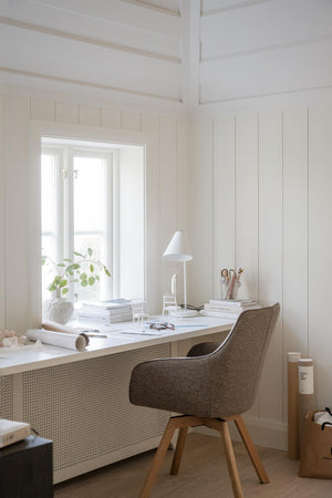 Ljust hemmakontor med vit skrivbordsstol i brunt tyg, vitt skrivbord och skandinavisk inredning