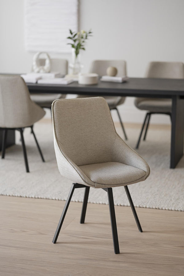 Beige matstol med svarta ben i modern skandinavisk design vid matbord