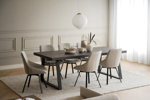 Matgrupp med svart bord och sex beige stolar i modern skandinavisk stil på ljus matta