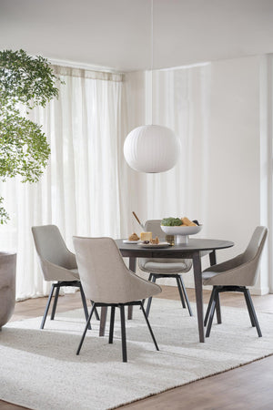 Matgrupp med runt svart bord och fyra grå stolar i modern skandinavisk stil med vit taklampa