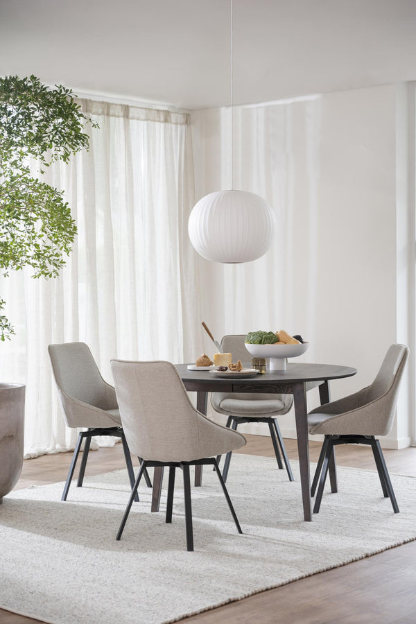 Matgrupp med runt svart bord och fyra grå stolar i modern skandinavisk stil med vit taklampa