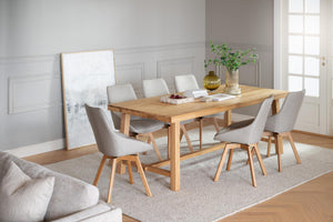 Matgrupp med ljust trä bord och sex grå stolar i modern skandinavisk matsal