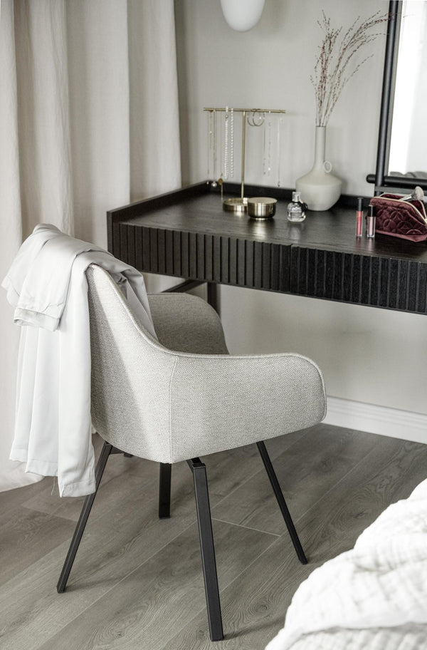 Ljusgrå matstol med svarta ben vid svart skrivbord i modernt sovrum med neutral inredning