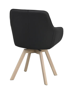 Svart matstol med ljusa träben, vy bakifrån som visar stoppad rygg och modern skandinavisk design