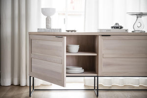 Skänk i ljust trä med öppna hyllor och skåp, svarta metallben, med dekoration och porslin