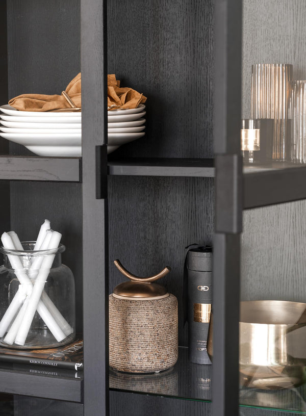 Moderna grå vitrinskåp med glasdörrar, vita tallrikar, dekorativa föremål i guld och glas