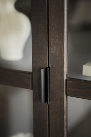 Mörkbrun träskåpsdörr med svart metallhandtag i modern minimalistisk design
