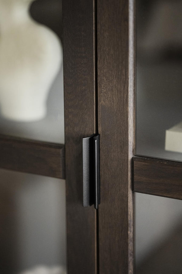 Mörkbrun träskåpsdörr med svart metallhandtag i modern minimalistisk design