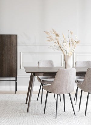 Matbord i trä med grå stoppade stolar i modern skandinavisk matsal med ljusa färger