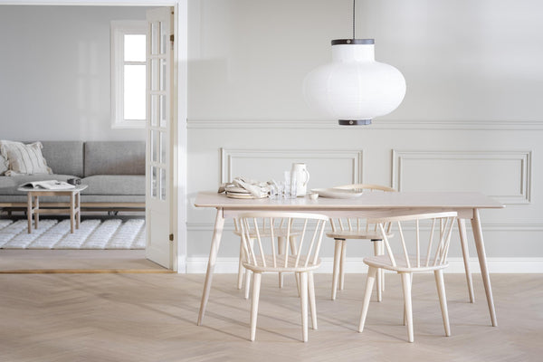 Ljus matplats med ljust trä matbord, stolar och vit taklampa i skandinavisk stil