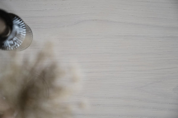 Fågel i snabb flygning med utsträckta vingar mot ljus träbakgrund, naturlig rörelseoskärpa