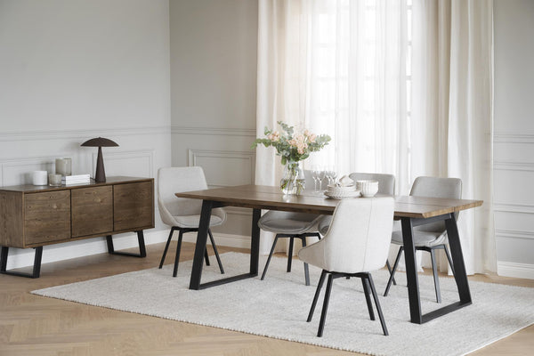 Matgrupp med träbord, fyra stolar och skänk i modern skandinavisk stil med ljust trägolv och vita gardiner