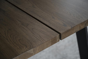 Närbild på massiv ekbordsskiva med synlig trästruktur och naturlig ådring i gråbrun ton