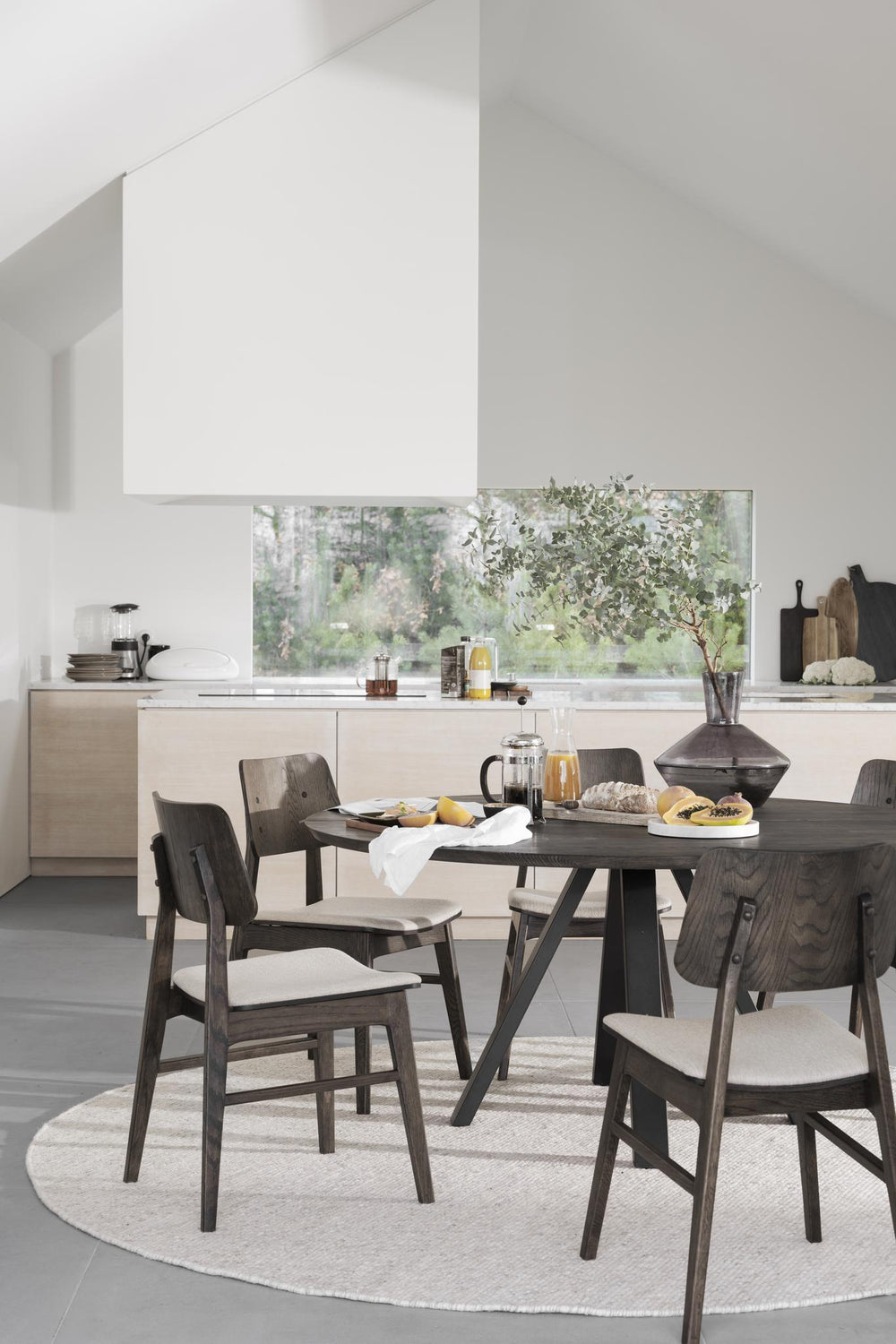 Matstol i mörkbetsad ek med beige stoppad sits och träryggstöd med dekorativa nitar