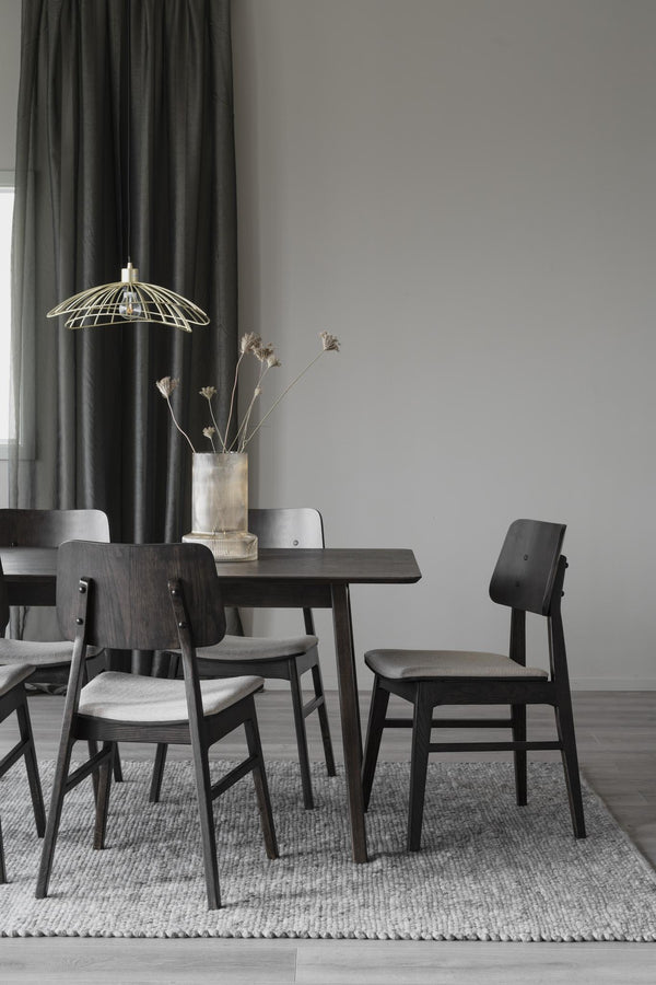 Matgrupp i svartbetsad ek med fyra stolar och rund pendant-lampa i skandinavisk stil