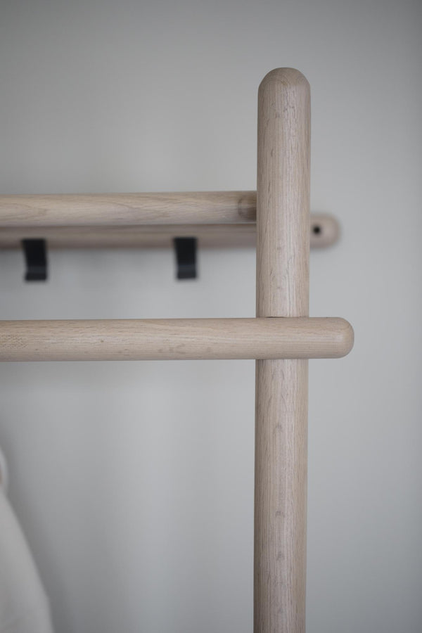 Närbild av ljust träräcke med vertikala stolpar och horisontella skenor i minimalistisk skandinavisk design