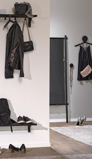 Svart hallmöbel med klädhängare, hylla och krokar med jacka, väskor och skor i modern skandinavisk stil