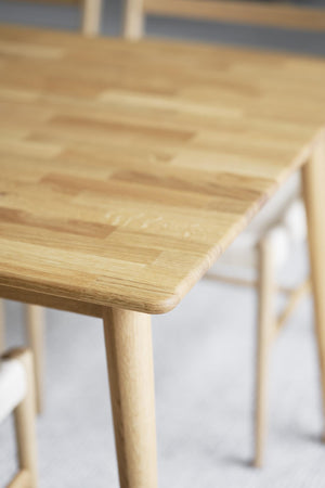 Massivt ek matbord med rundade hörn och naturlig trästruktur, närbild av bordsskiva och ben