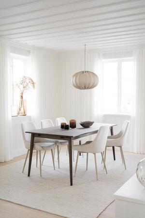 Minimalistisk matsal med grå matbord, vita stolar och beige taklampa i skandinavisk stil