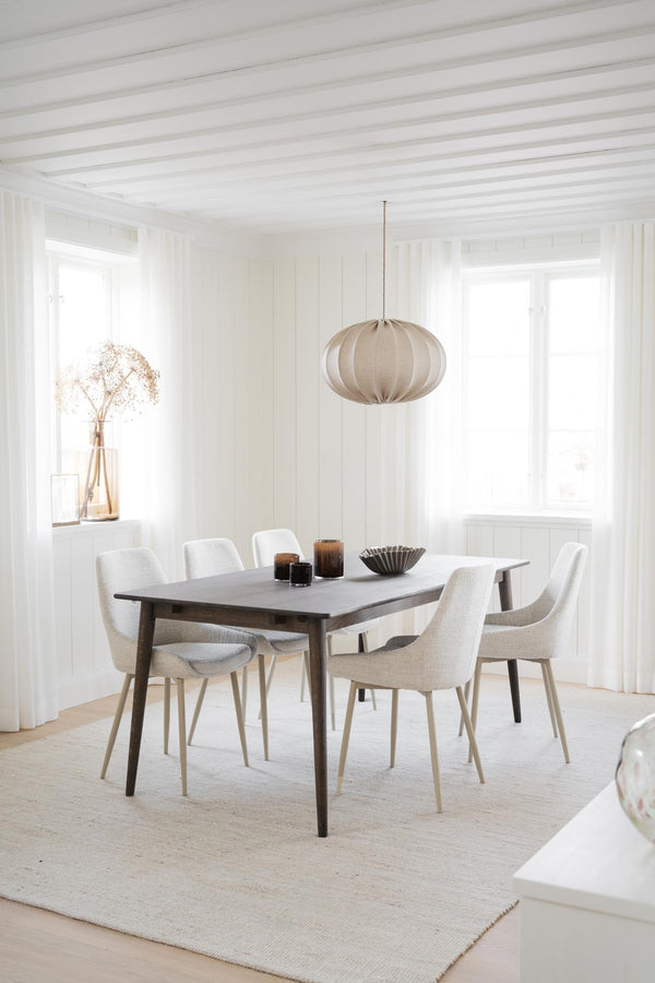 Minimalistisk matsal med grå matbord, vita stolar och beige taklampa i skandinavisk stil