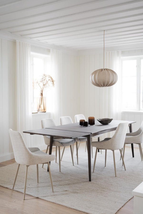 Matgrupp med grått matbord och ljusa stoppade stolar i skandinavisk stil med taklampa