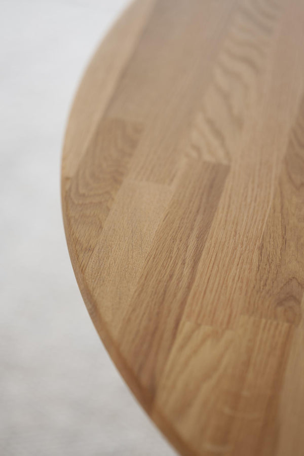 Närbild av rund träskärbräda i ljust trä med naturlig ådring och slät yta