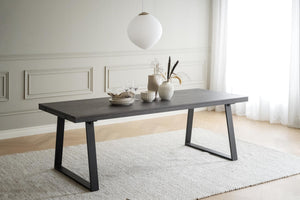 Modernt matbord i mörkt trä med svarta metallben i minimalistisk matsal med vit inredning