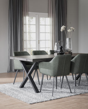 Matgrupp med grå stolar och bord med korsben i modern matsal med ljusinsläpp från fönster