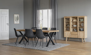 Matgrupp med bord i ek och svarta stolar på grå matta, vitrinskåp i bakgrunden, modern skandinavisk design