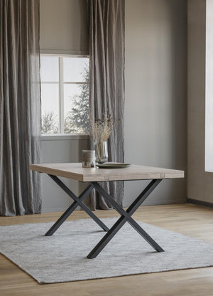 Matbord med ljus träskiva och svarta korslagda metallben i modern skandinavisk stil