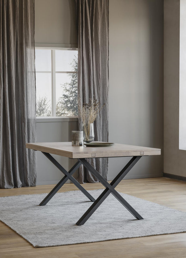 Matbord med ljus träskiva och svarta korslagda metallben i modern skandinavisk stil