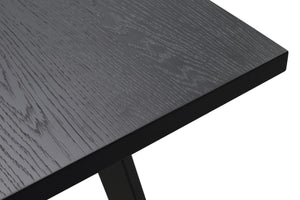 Närbild av svart träbordsskiva med synlig trästruktur och massiv svart metallbas