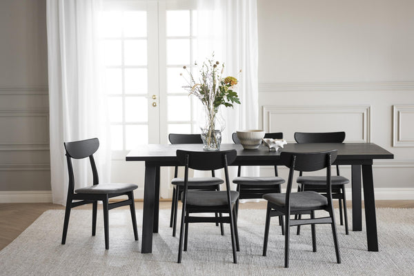 Svart matbord med matchande stolar i modern skandinavisk stil, ljust matrum med franska dörrar