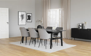 Matbord i svart med sex stolar i grå och svart i modern matsal med trägolv