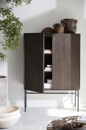 Skåp med räfflad yta i mörkbrun färg på metallstativ, öppna dörrar visar hyllor med böcker